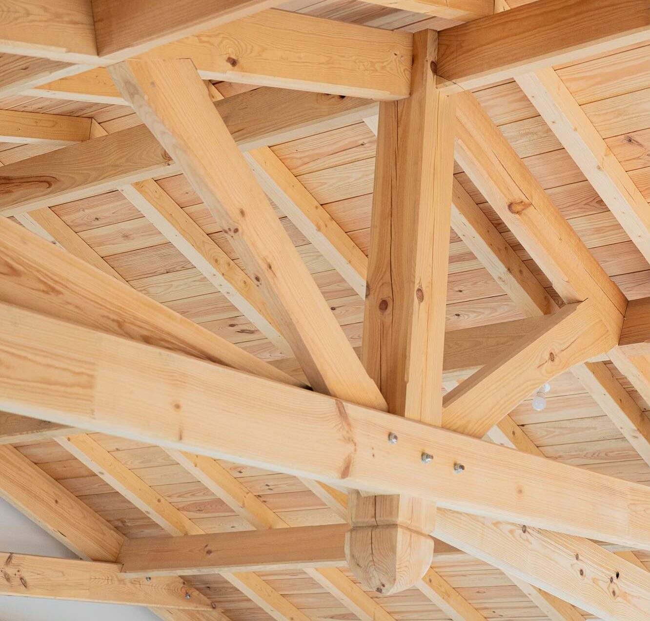 Charpente en bois massif avec poutres et assemblages apparents sous une toiture, exemple de structure à inspecter dans le Sud-Ouest